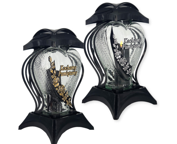 Duży znicz z napisem "Kochamy Pamiętamy" i ozdobnym kwiatem