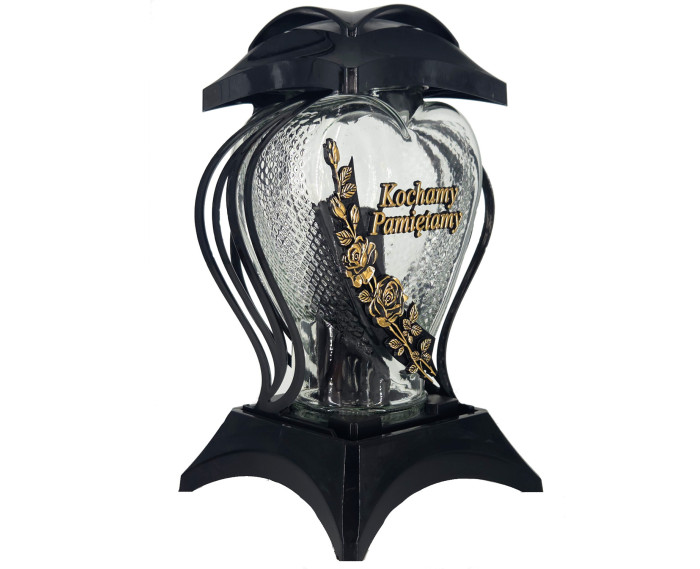 Duży znicz z napisem "Kochamy Pamiętamy" i ozdobnym kwiatem